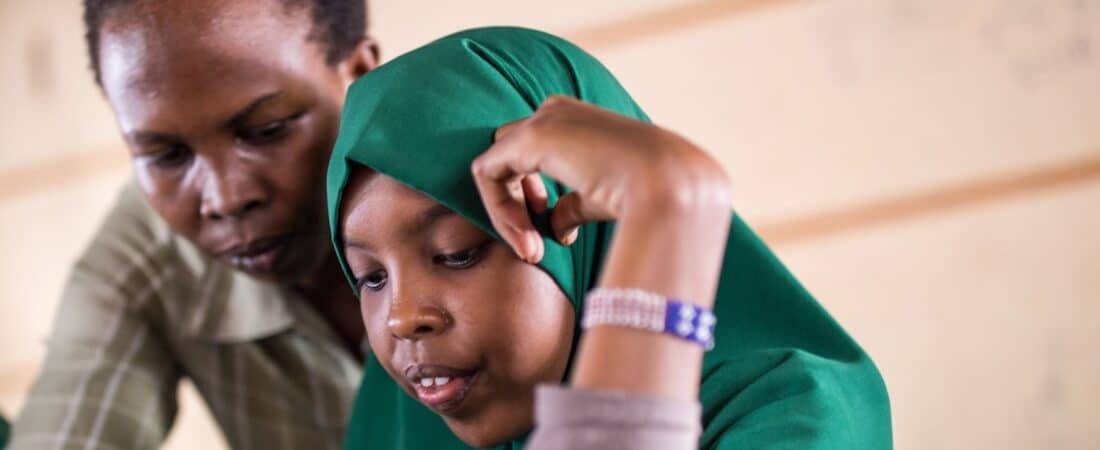 A student reviews her lessons with the support of a teacher in Dadaab, Kenya. © Lorenzo Moscia