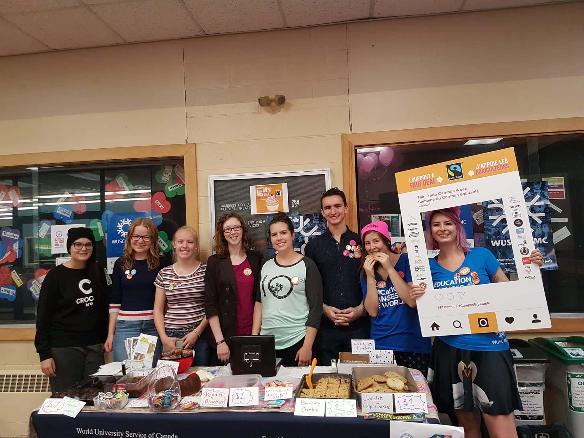 A group of post-secondary students host a bake sale on their campus.