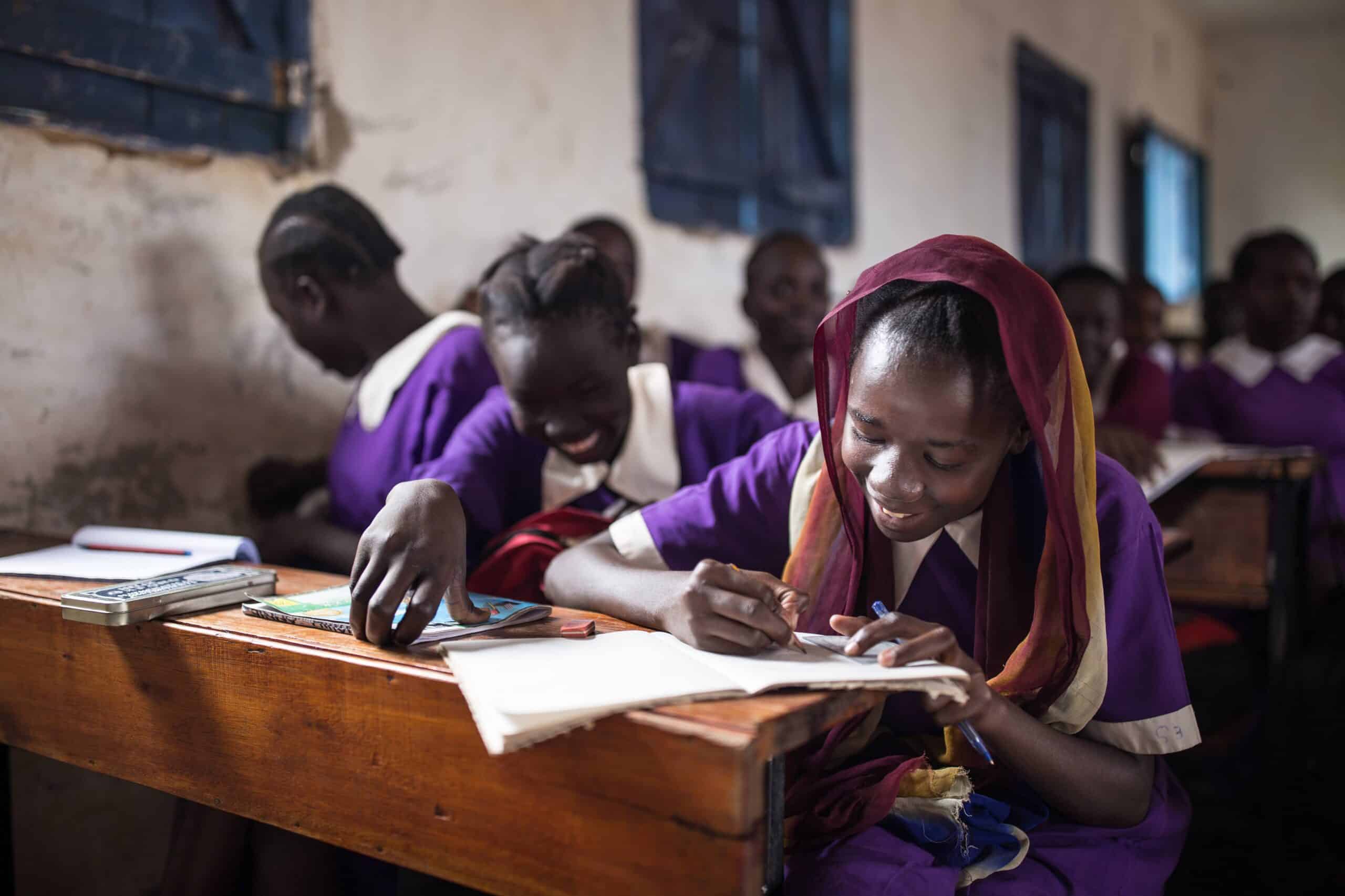 A student writes in her notebook in a classroom in Kenya.