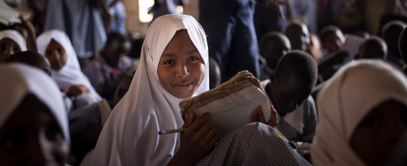 Légende: Une jeune fille dans une salle de classe du camp de personnes réfugiées de Kakuma, au Kenya. Photo : Lorenzo Moscia.